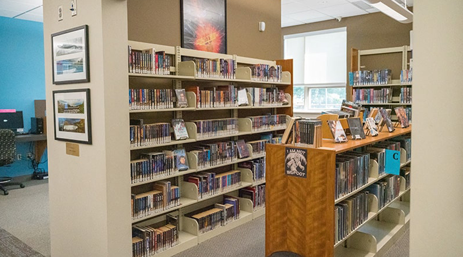 Photograph of the Jesse M. Smith Memorial Library interior featuring full bookcases and bookshelves