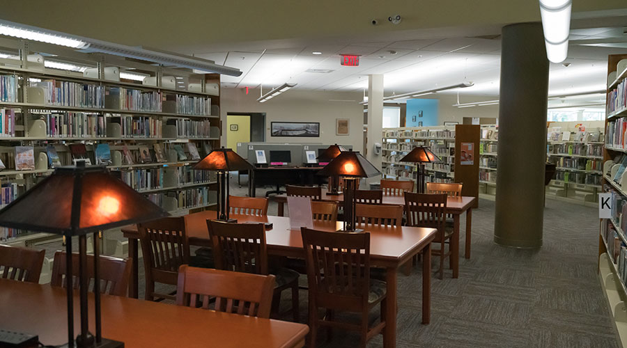 Library interior, featuring tables and chairs for personal use.